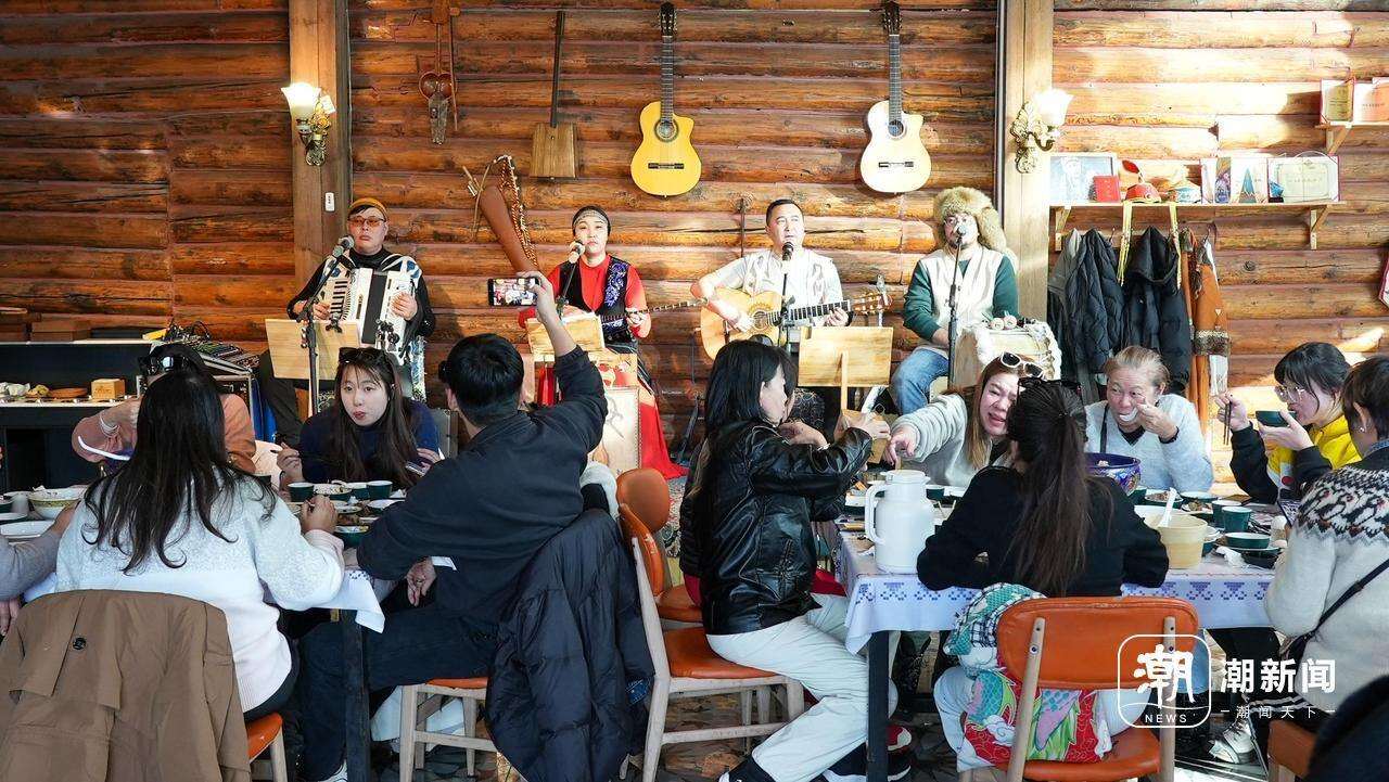 【】3-4 百年木屋内,马来西亚游客在欣赏特色表演。记者 潘骏 摄.jpg