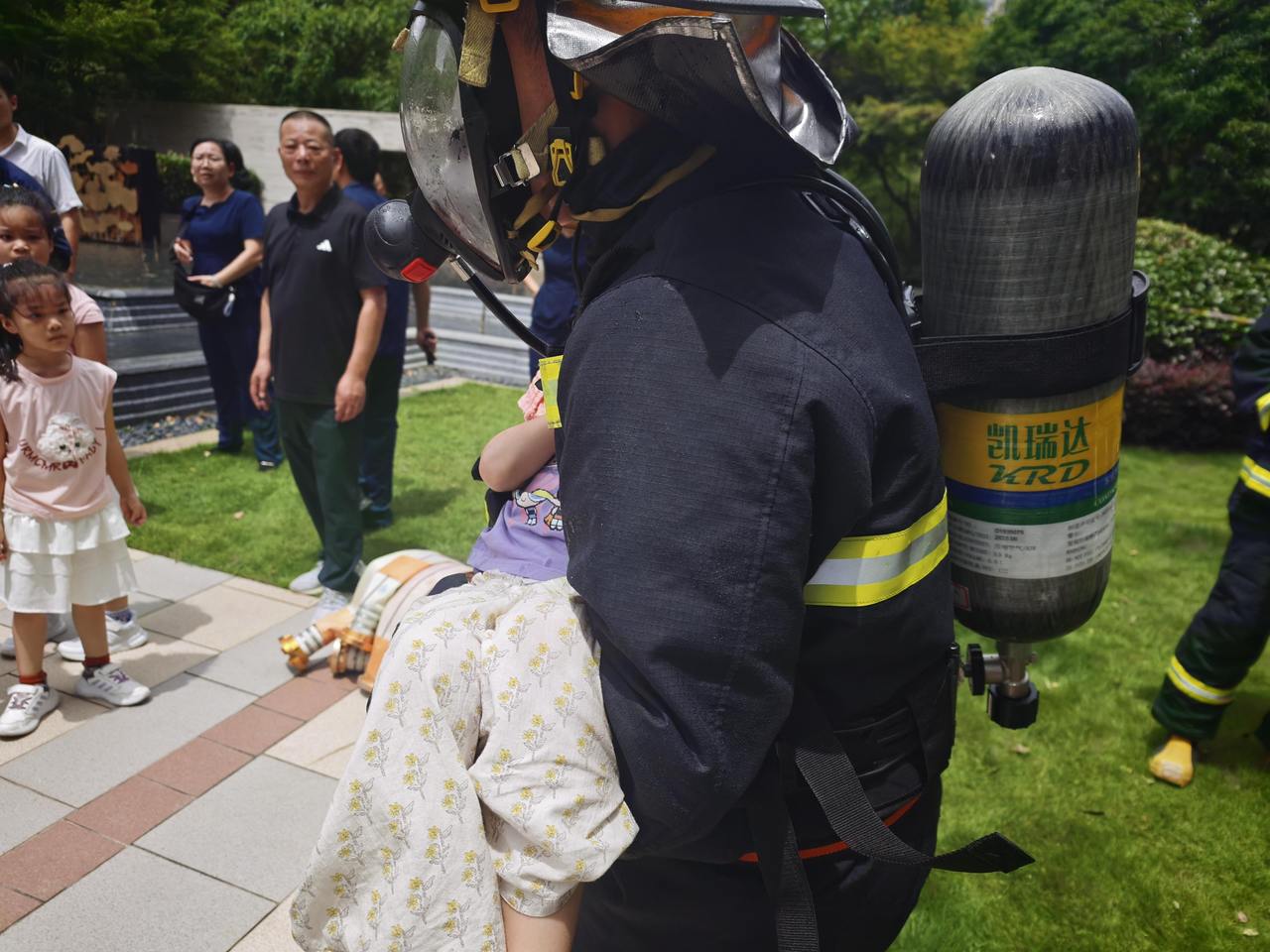 刘轩岐抱着小女孩转移至起火单元楼一楼交给救护人员.jpg